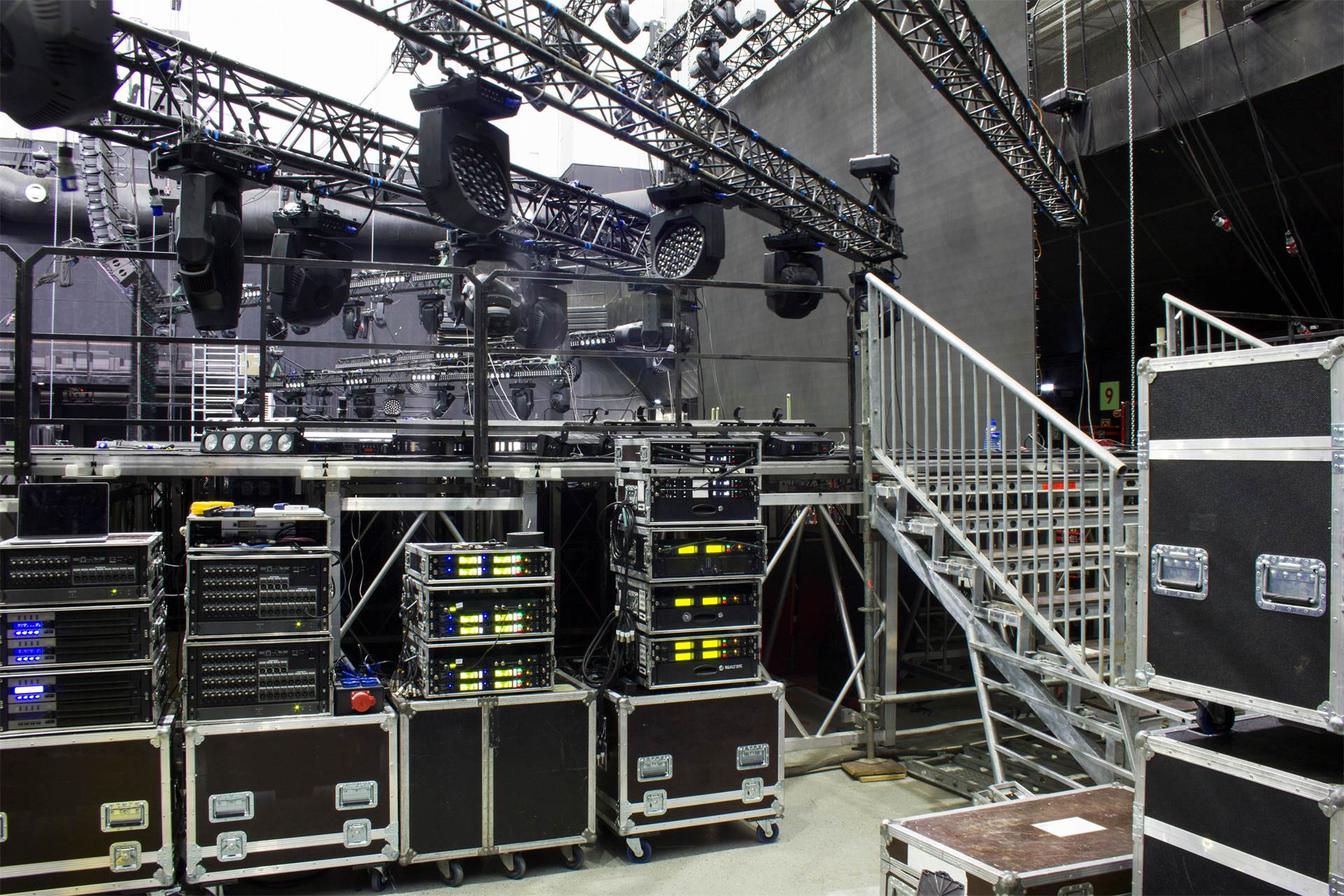 Coulisses techniques : structures, projecteurs asservis et racks de sonorisation